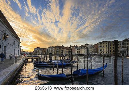 Stock Image - Gondolas Mooring In The Water At Sunrise; Venice, Italy. Fotosearch