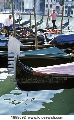 Stock Image - Gondolas On Grand Canal With Two Gondoliers In The Background. Fotosearch