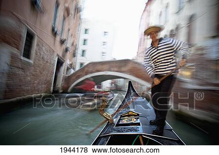 Stock Photo - Gondolier On A Gondola In A Canal; Venice Venezia Italy. Fotosearch