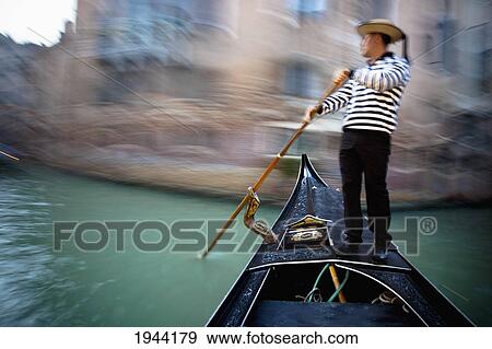 Stock Photo - Gondolier On A Gondola In A Canal; Venice Venezia Italy. Fotosearch
