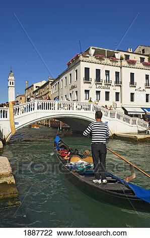 Gondolier On Gondola In Canal In Venice. View Large Photo Image Stock Image - Gondolier On Gondola In Canal In Venice.. Fotosearch