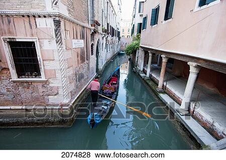 Stock Photo - Gondoliero Rowing A Gondola In A Canal, Venice, Italy. Fotosearch