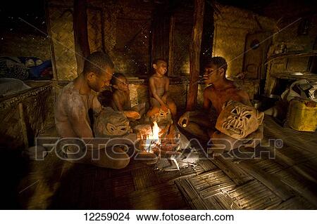 Picture - Goroka mudmen gathered around a fireplace; Goroka, Eastern Highlands, Papua New Guinea. Fotosearch