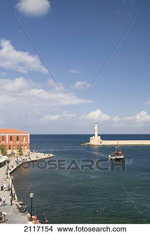 Picture - Greece, Crete, 16th Century Venetian Harbor and lighthouse, People enjoying the afternoon.. Fotosearch