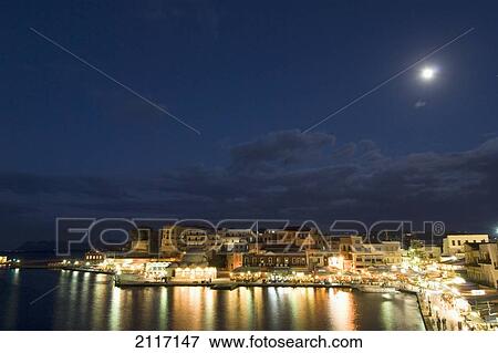 Stock Photo - Greece, Crete, 16th Century Venetian Harbor at night, Light reflecting in water.. Fotosearch