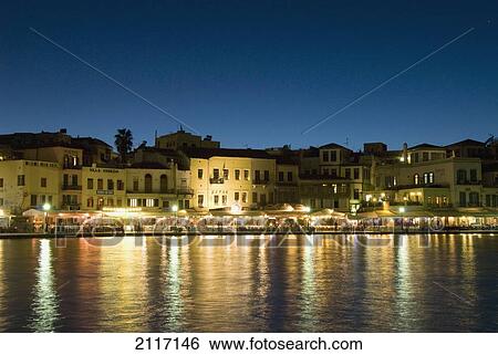 Stock Photograph - Greece, Crete, 16th Century Venetian Harbor at night, Light reflecting in water.. Fotosearch