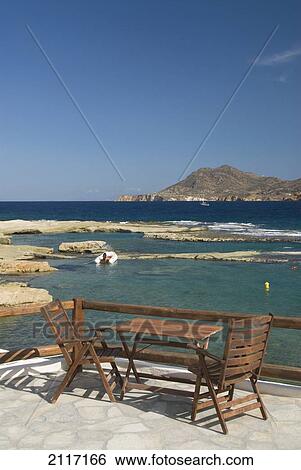 Greece, Cyclades, Island of Milos, Village of Polonia, A table overlooking the bay. View Large Photo Image Stock Photograph - Greece, Cyclades, Island of Milos, Village of Polonia, A table overlooking the bay.. Fotosearch