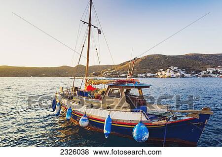 Stock Photo - Greece, Greek Islands, Fishing Boat, Classic Mountain Town In Distance.. Fotosearch