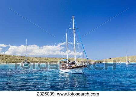 Greece, Greek Islands, Sailboat, Classic Mountain Town In Distance. View Large Photo Image Stock Photo - Greece, Greek Islands, Sailboat, Classic Mountain Town In Distance.. Fotosearch