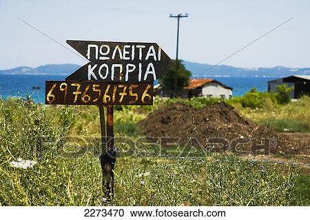Stock Image - Greece, Halkidiki, Sign written in Greek saying manure for sale; Ierissos. Fotosearch