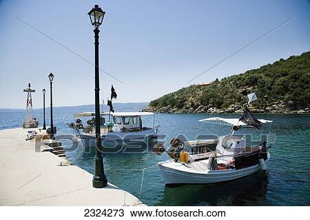 Stock Image - Greece, Halkidiki, Traditional wooden fishing boats moored in small harbour; Pirgadikia. Fotosearch