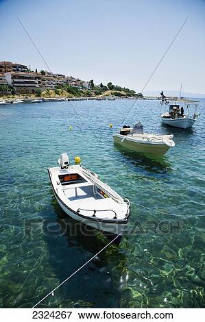 Stock Photo - Greece, Halkidiki, Traditional wooden fishing boats moored in small harbour; Pirgadikia. Fotosearch