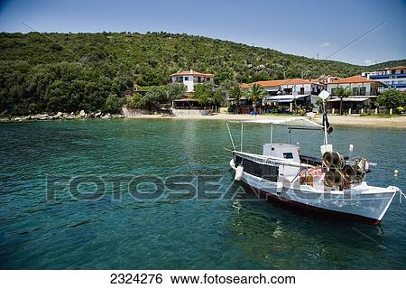 Stock Photograph - Greece, Halkidiki, Traditional wooden fishing boat moored in small harbour; Pirgadikia. Fotosearch