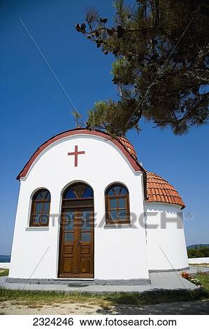 Stock Photograph - Greece, Halkidiki, Whitewashed Greek Orthodox church overlooking Mediterranean sea; Nea Roda. Fotosearch