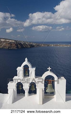 Picture - Greece, Santorini, Oia, Architectural detail of Greek Orthodox Chrurch bell tower, Mediterranean Sea and Island of Thirassia in the distance.. Fotosearch