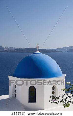 Stock Image - Greece, Santorini, Oia, Architectural detail of Greek Orthodox Chrurch, Island of Thirassia in the distance.. Fotosearch