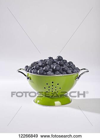 Stock Photo - Green colander filled with fresh blueberries. Fotosearch