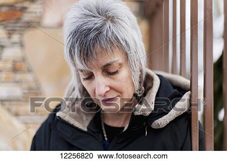 Stock Image - Grey-haired woman with fashionable haircut looking down; Langley, British Columbia, Canada. Fotosearch