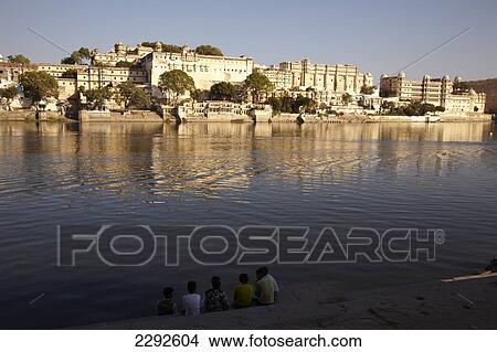 Picture - Group of boys and the city palace of Udaipur Rajasthan India. Fotosearch