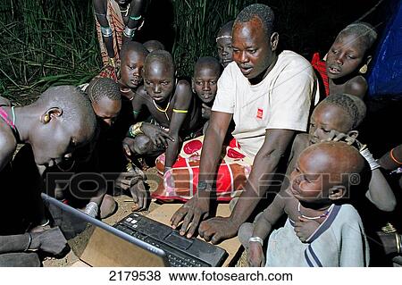 Group of Mursi tribal children looking in owe at the first Mursi owned laptop computer been operated in the deep of night. Makki / South Omo / Southern Nations, Nationalities & People's Region (Ethiopia). View Large Photo Image Stock Photo - Group of Mursi tribal children looking in owe at the first Mursi owned laptop computer been operated in the deep of night. Makki / South Omo / Southern Nations, Nationalities & People's Region (Ethiopia).. Fotosearch