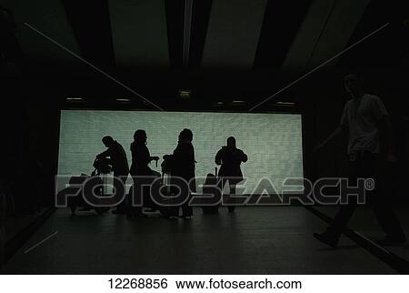 Group of passengers with luggage silhouetted at the Charles de Gaulle Airport, Paris, France View Large Photo Image Stock Photograph - Group of passengers with luggage silhouetted at the Charles de Gaulle Airport, Paris, France. Fotosearch