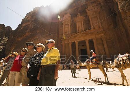 Group of tourists having their picture taken while standing in front of the Treasury; Petra, Jordan View Large Photo Image Stock Photo - Group of tourists having their picture taken while standing in front of the Treasury; Petra, Jordan. Fotosearch