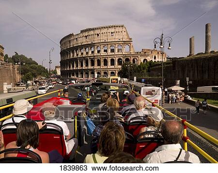 Stock Image - Group Of Tourists Sitting On Bus And Looking At Colosseum.; Rome, Italy. Fotosearch