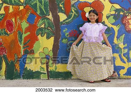 Stock Image - Guam, Full Length View Of Smiling Local Girl, In Front Of Colorful Painted Wall. Fotosearch