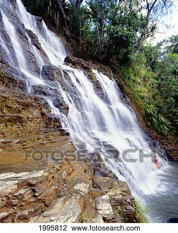 Stock Image - Guam, Inajaran, Talofofo Lower Falls, Woman At Bottom In Rushing Water. Fotosearch