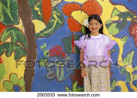 Stock Image - Guam, Smiling Local Girl In Chamorro Costume Stands In Front Of Colorful Wall. Fotosearch