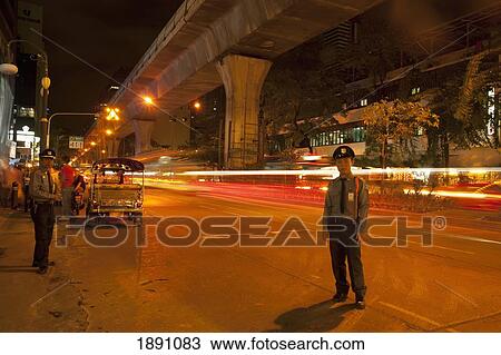 Stock Image - Guards Help Guide Traffic On Silom Road; Bangkok, Thailand. Fotosearch