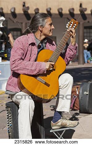 Stock Photograph - Guitarist performing for tourists in Historic Plaza in downtown; Santa Fe, New Mexico, USA. Fotosearch