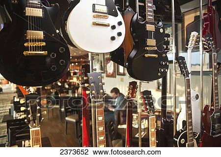 Stock Image - Guitars on display in a musical instrument shop; Singapore. Fotosearch