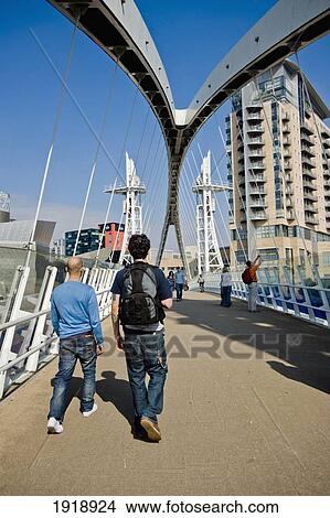 Guys Crossing The Lowry Footbridge Over The Ship Canal In Salford Quays, Manchester, England, Uk View Large Photo Image Picture - Guys Crossing The Lowry Footbridge Over The Ship Canal In Salford Quays, Manchester, England, Uk. Fotosearch