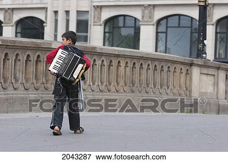 Stock Photo - Gypsy Accordion Player Walking On A Bridge, Berlin, Germany. Fotosearch