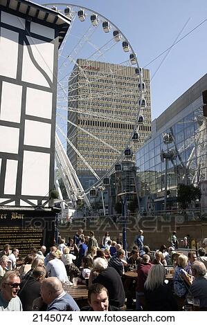 Picture - Half timbered pub, with the Wheel of Manchester in the background, Shambles Square; Manchester, Lancashire, England. Fotosearch