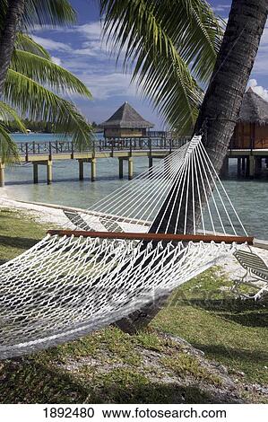 Stock Image - Hammock Near Holiday Huts At Lagoon. Fotosearch