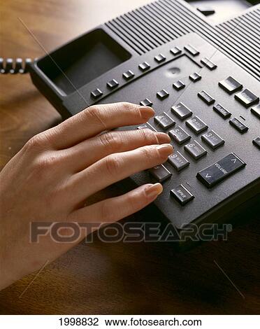 Stock Image - Hand At Telephone Keypad B1175. Fotosearch