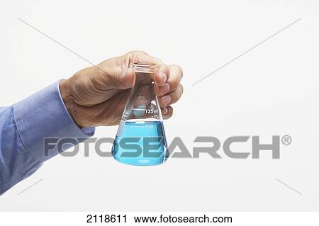 Stock Image - Hand Holding Beaker Of Blue Liquid. Fotosearch