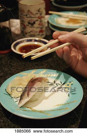 Hand Holding Chopsticks Over Sushi Plate, Close Up View Large Photo Image Stock Photograph - Hand Holding Chopsticks Over Sushi Plate, Close Up. Fotosearch