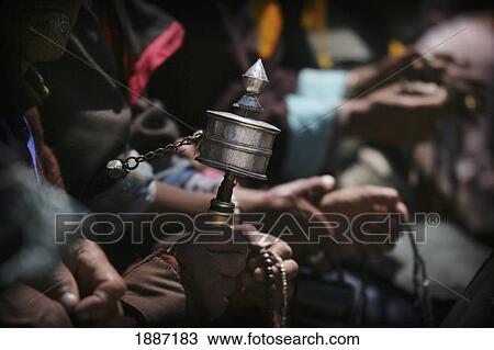 Stock Image - Hands And Spinning Prayer Wheel, Close Up. Fotosearch