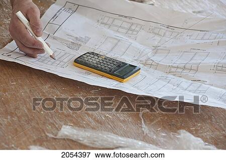 Stock Photo - Hands Of Contractor Writing Down Measurements On Set Of Blueprints, Ontario. Fotosearch