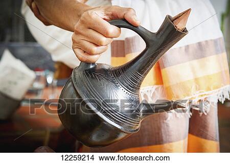 Hands pouring Ethiopian coffee out of traditional jebena; Takoma Park, Maryland, United States of America View Large Photo Image Picture - Hands pouring Ethiopian coffee out of traditional jebena; Takoma Park, Maryland, United States of America. Fotosearch