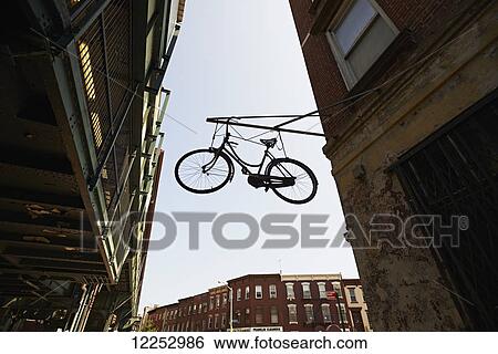 Stock Photograph - Hanging bicycle in Williamsburg, Brooklyn; New York City, New York, United States of America. Fotosearch