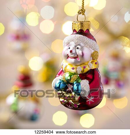 Picture - Hanging Santa Christmas ornament with out of focus ornaments in the background; Victoria, British Columbia, Canada. Fotosearch