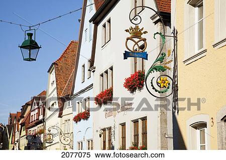 Stock Photography - Hanging Sign And Lantern With Blossoming Flowers In Window Planter Boxes; Rothenburg Ob Der Tauber Bavaria Germany. Fotosearch