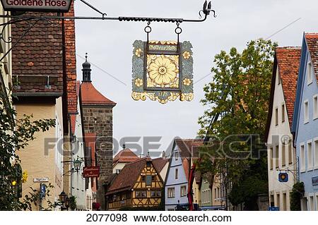Stock Photo - Hanging Sign With A Gold Flower On An Urban Street; Rothenburg Ob Der Tauber Bavaria Germany. Fotosearch