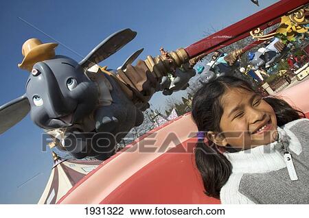 Stock Image - Happy Little Girl On The Dumbo Ride, Fantasyland, Disneyland, Paris, France; Paris, France. Fotosearch
