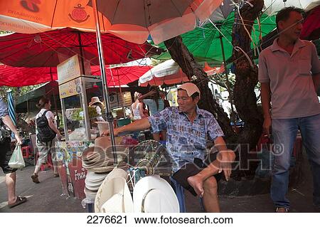 Stock Image - Hat vendor at the market; Bangkok, Thailand. Fotosearch