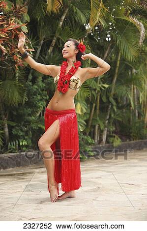 Stock Image - Hawaii, A Local Hawaiian Woman Wearing A Red Lei And Dancing The Hula.. Fotosearch